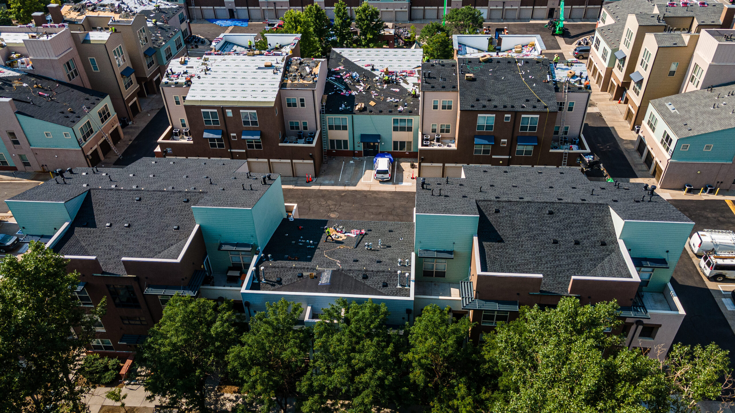 Overhead shot of apartment buildings undergoing roofing repairs