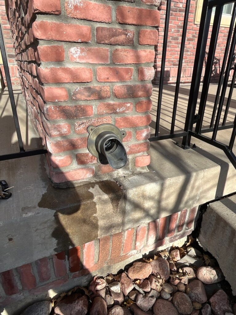 Commercial downspout coming out of a wall repaired