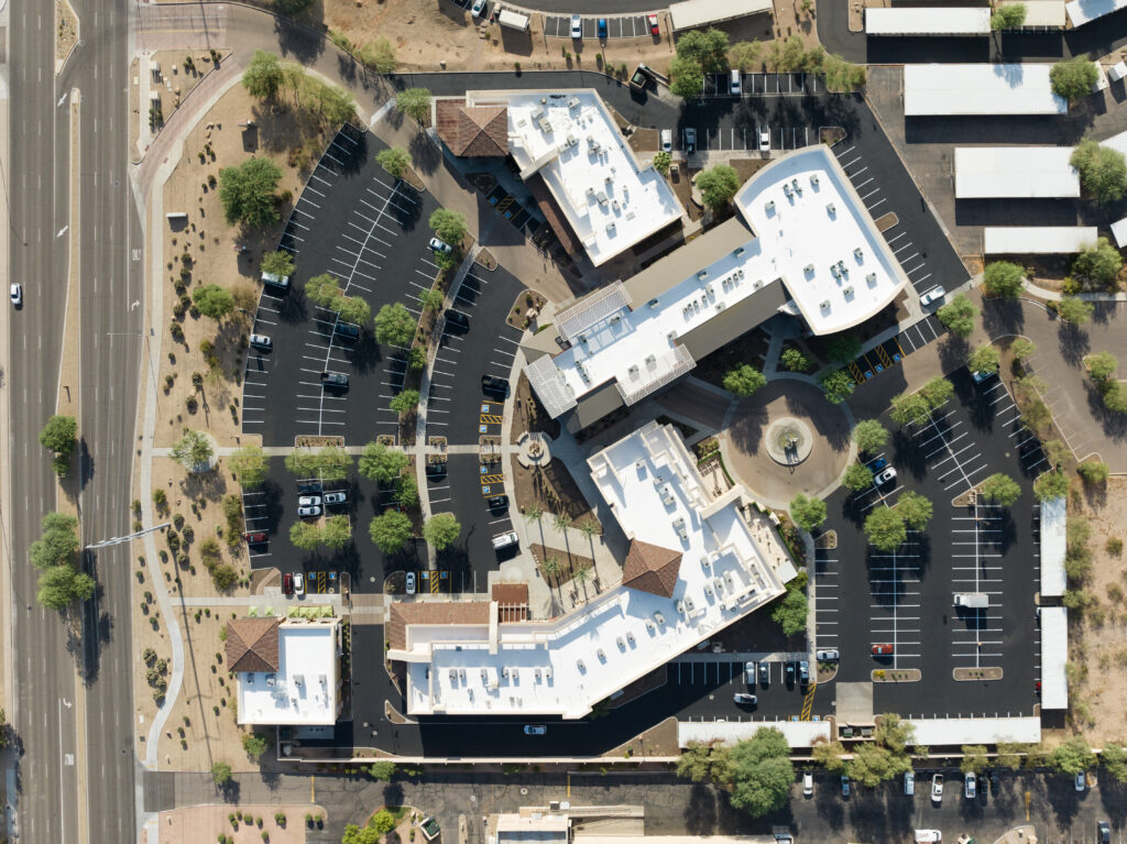 An aerial view of a large commercial building with a newly replace roof with multiple mechanical units